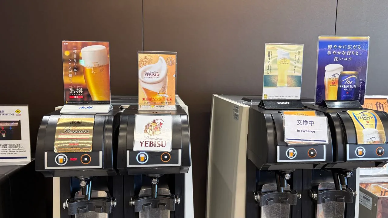 Four self-pour beer machines in two pairs, labelled Asahi Jukusen, Yebisu, Kirin Ichiban Shibori Premium and The Premium Malt's, with an in-exchange card on the Kirin machine